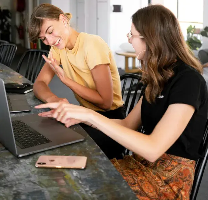 Two Women Working Together On A Laptop
